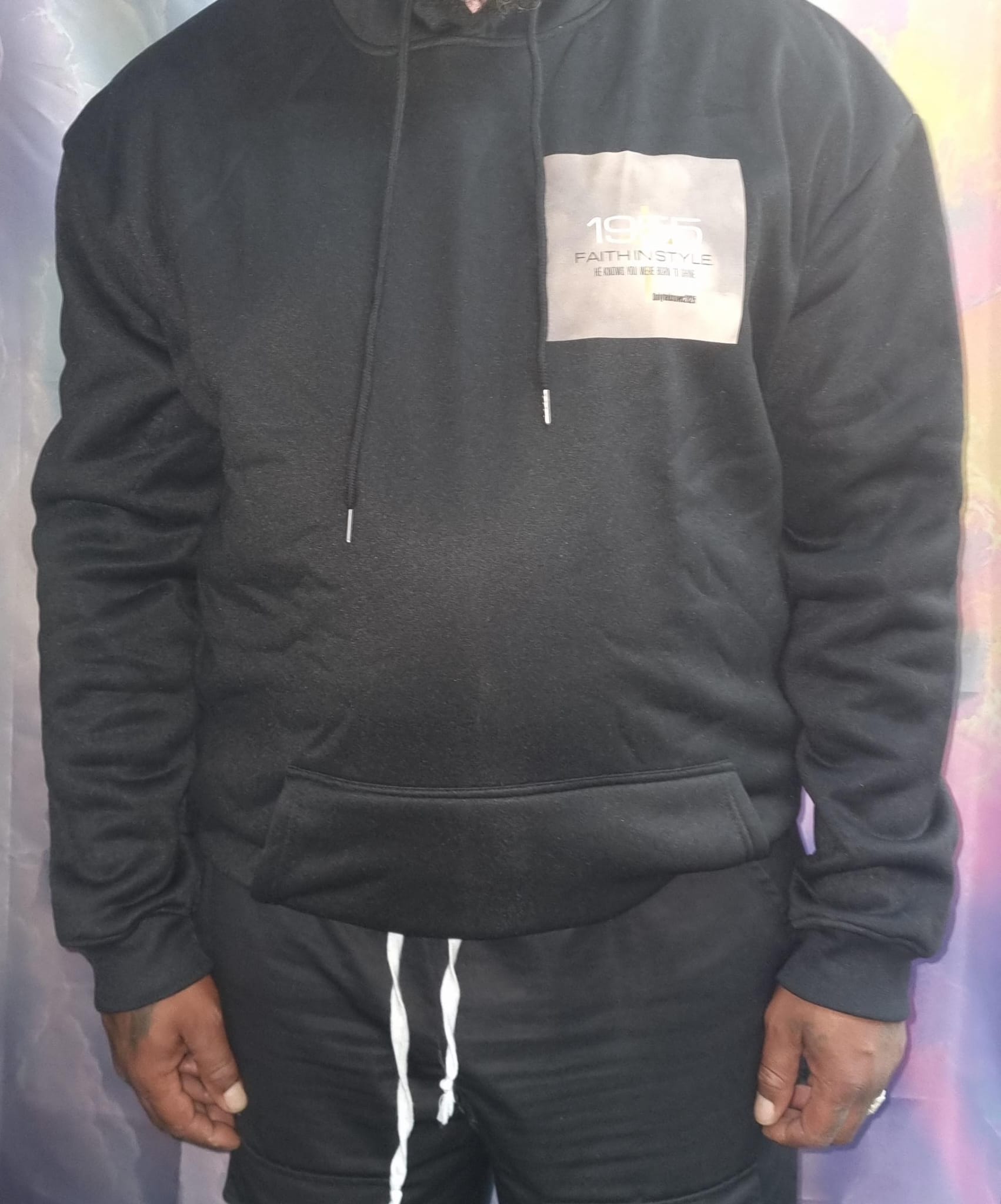 Close-up van de voorkant van de OnlyHeKnows25® Limited Edition Zwarte Hoodie ‘Jesus Is King’, met stijlvolle branding en comfortabele pasvorm, ontworpen voor de modebewuste gelovige.