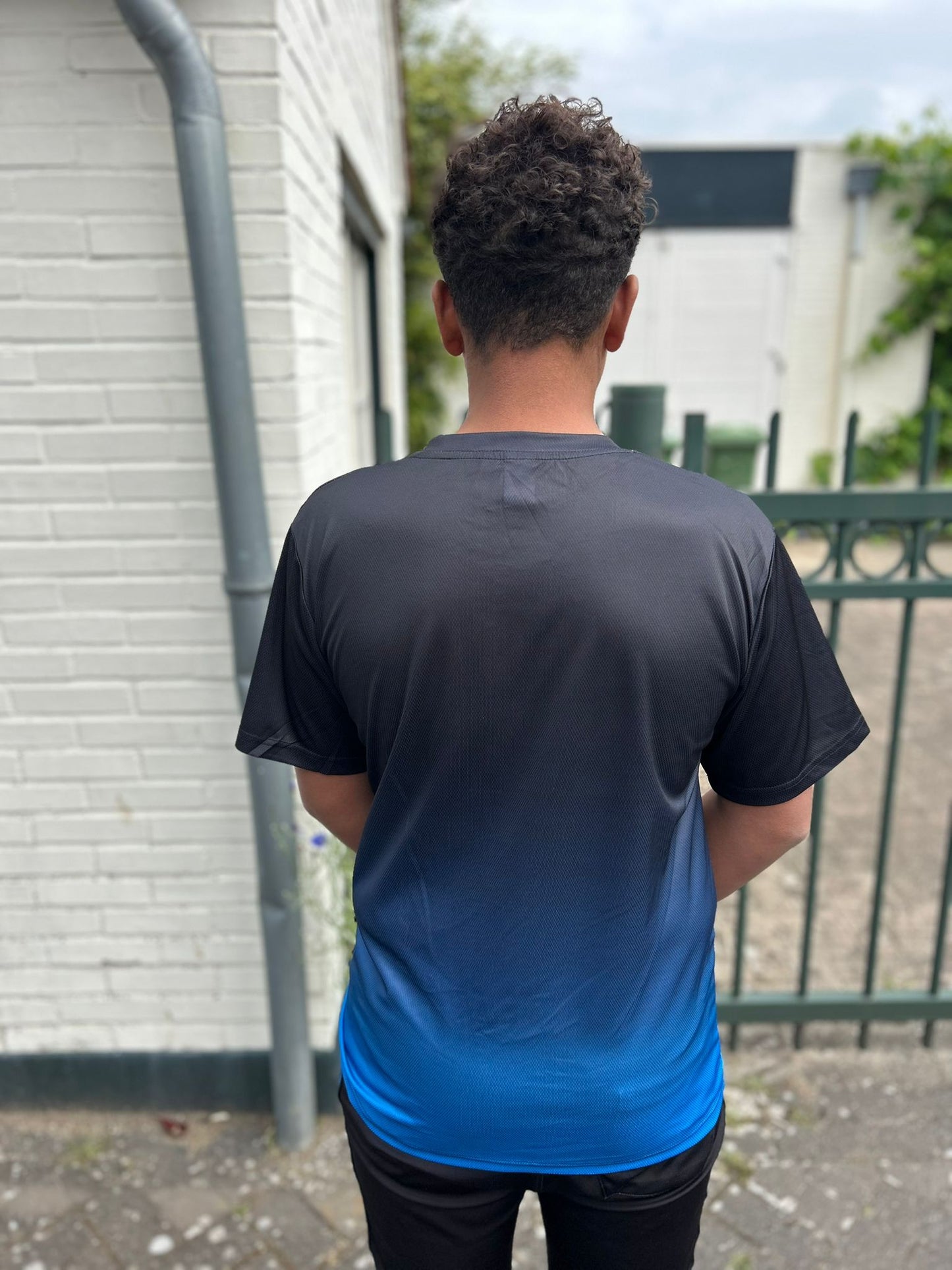 Achteraanzicht van Christus T-Shirt van Onlyheknows2025, zwart en blauw met inspirerende tekst, perfect voor jongeren die hun geloof en stijl willen combineren.