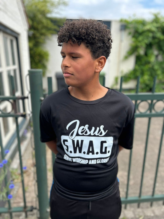 Jongen in een stijlvolle zwarte Jesus S.W.A.G. T-shirt - Saved With A Goal van Onlyheknows2025, met de tekst 'Serve Worship and Glorify' zichtbaar, perfect voor moderne gelovigen.