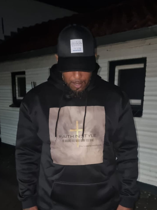 Modebewuste man in de OnlyHeKnows25® Limited Edition Zwarte Hoodie ‘Jesus Is King’, gemaakt van premium katoen/polyester, met een krachtige boodschap en comfortabele pasvorm.