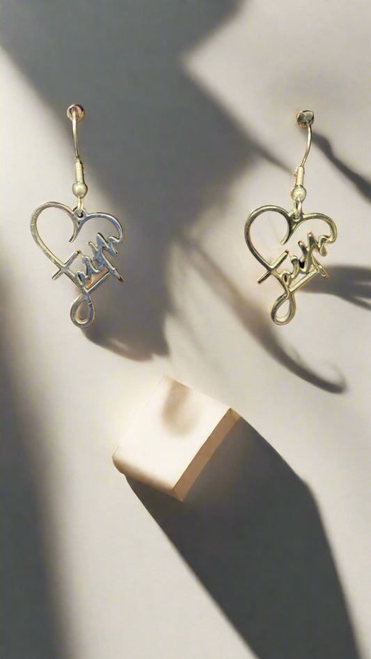 Faith Heart Earrings – Geloof in stijl: elegante hartvormige oorbellen met het woord Faith, goudkleurig en perfect voor elke outfit.