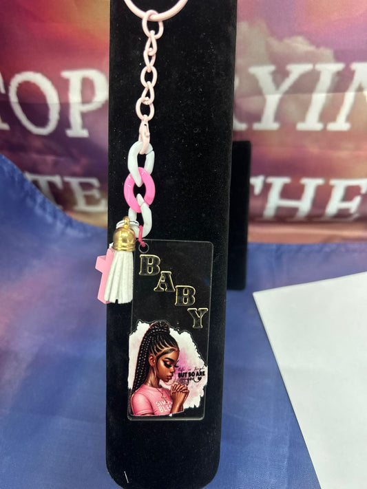 Sleutelhanger 'BABY BLESSED' met stijlvolle print van een zelfverzekerde vrouw, goudkleurige details en speelse tassel, perfect voor vrouwen die God volgen met flair.